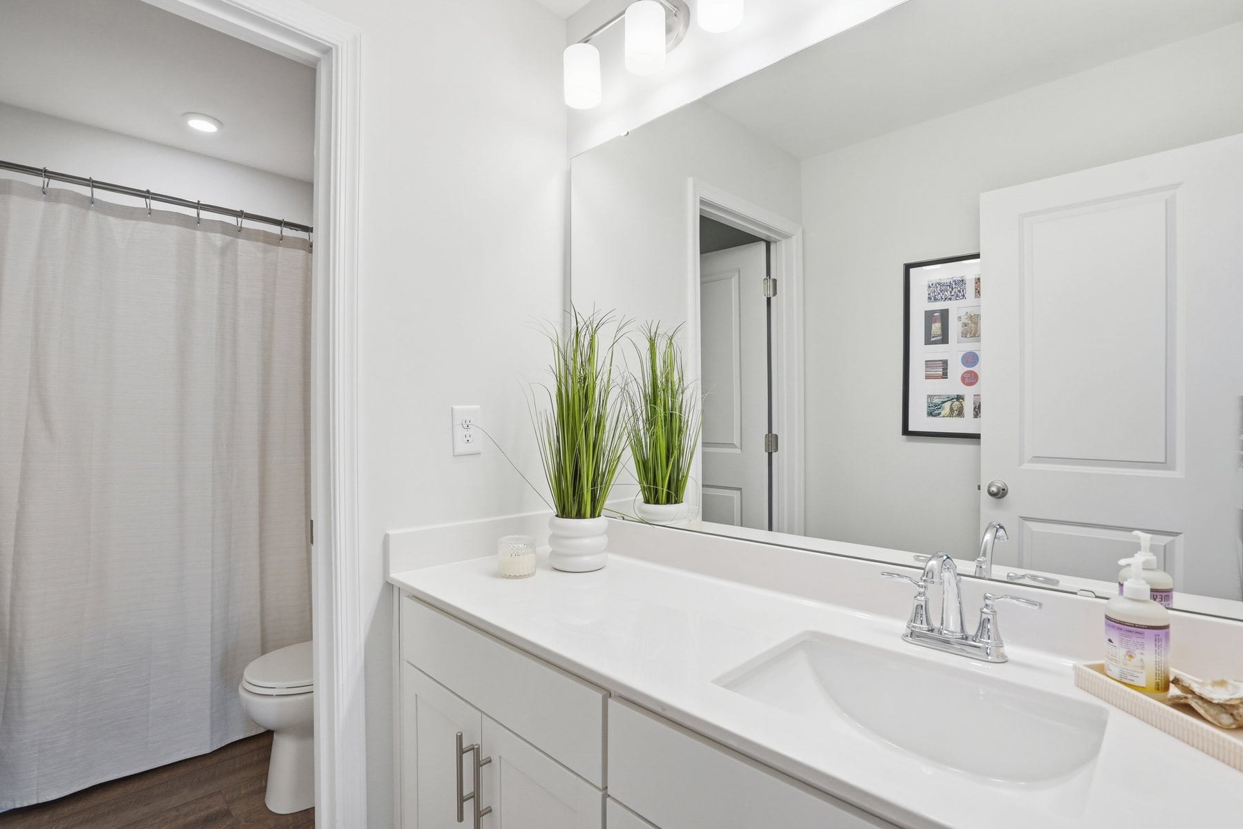 Bath with a white vanity, framed mirror and a walk-in shower