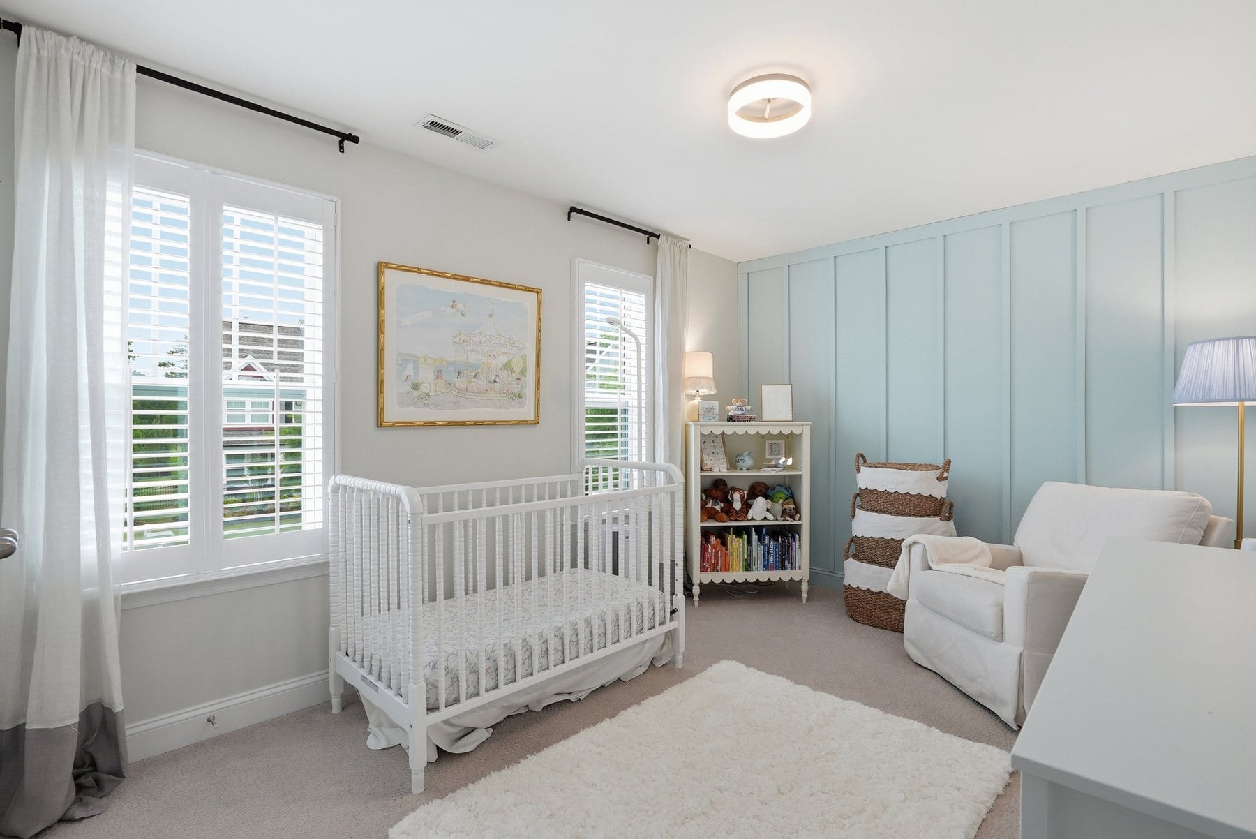 Bedroom with a crib, dresser and windows
