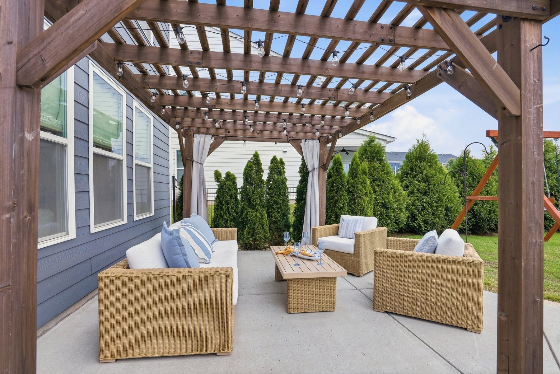 Back yard with a stone fire pit, patio and a swing set